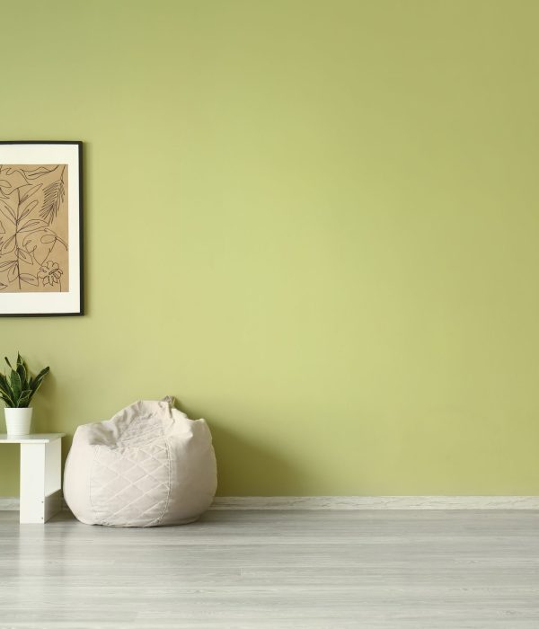 Beanbag and table near color wall with picture